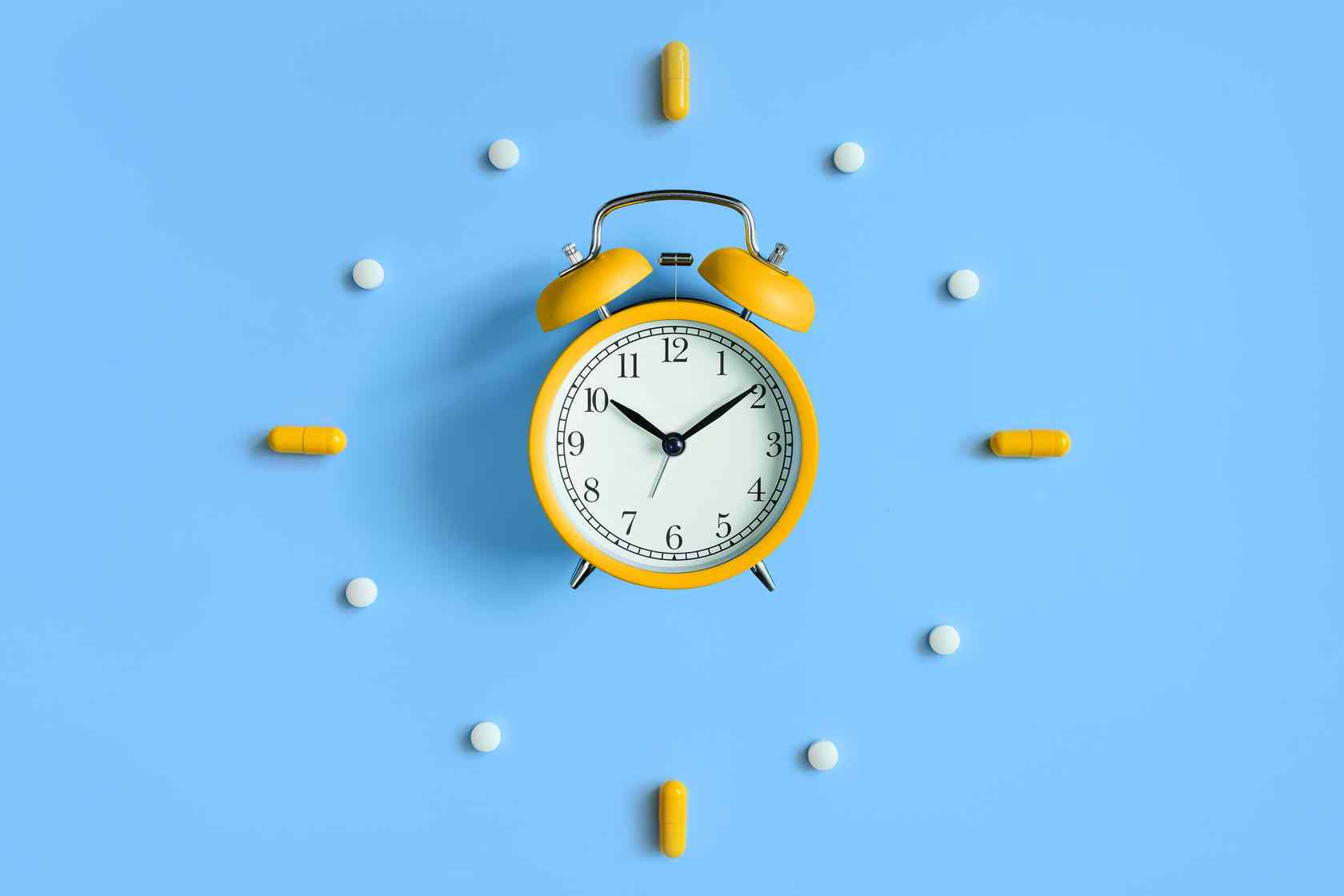 Yellow clock with supplements laid out around it