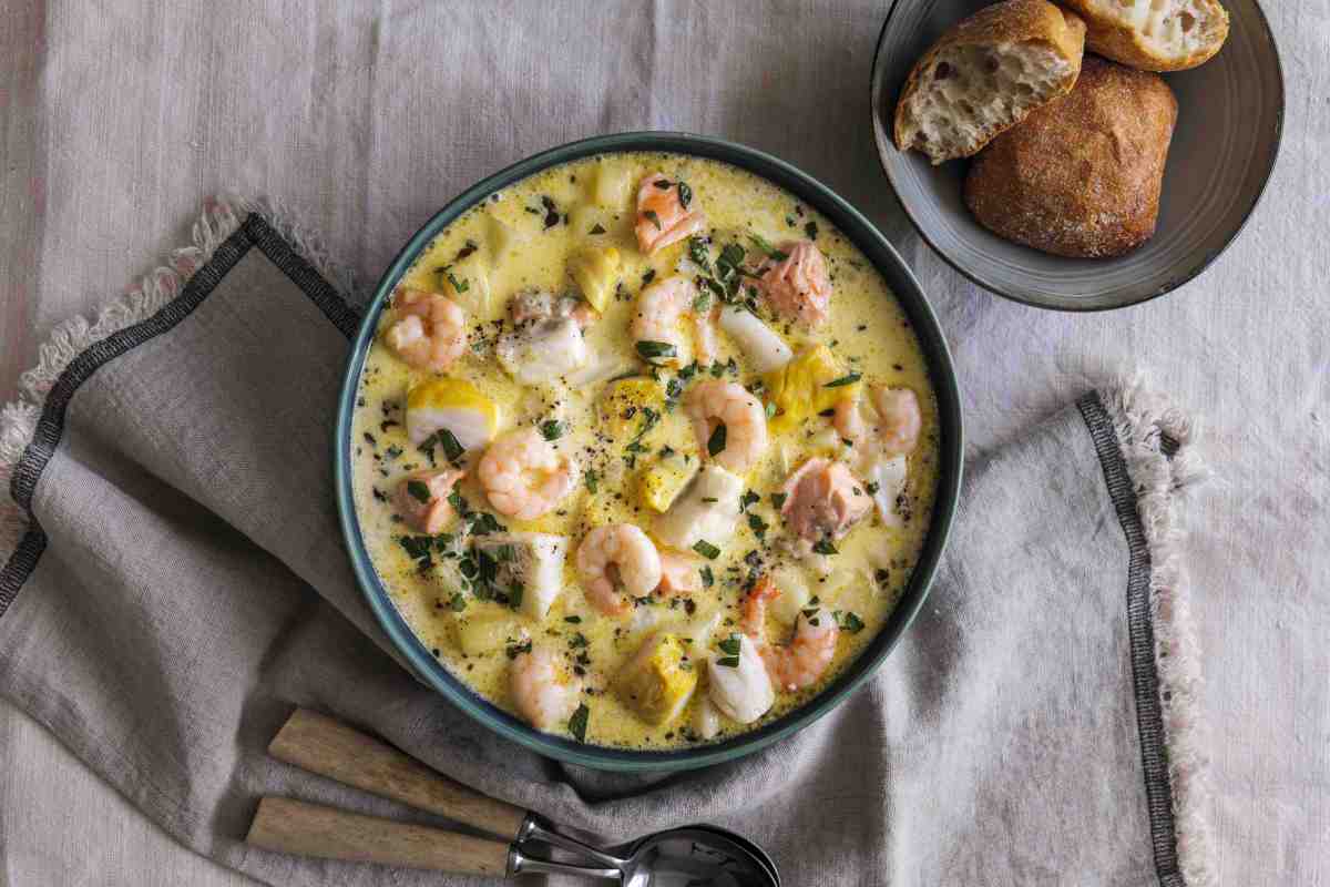 Prawn chowder in a bowl with some bread